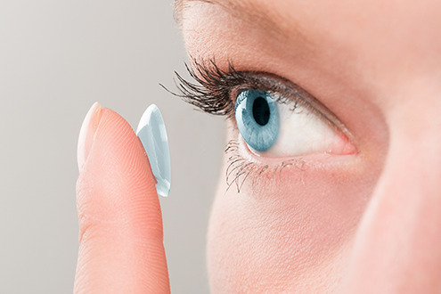 a woman applying contact lenses